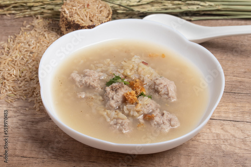 Jasmine brown rice porridge with pork on wooden background.Healthy food copy space