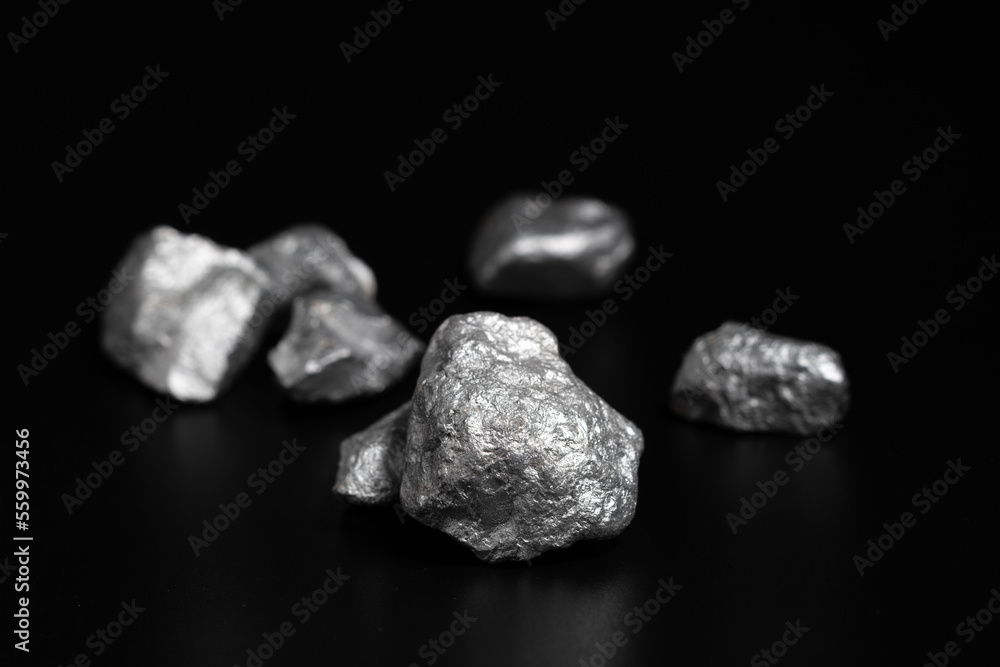 Naklejka premium lump of silver or platinum or rare earth minerals on black background