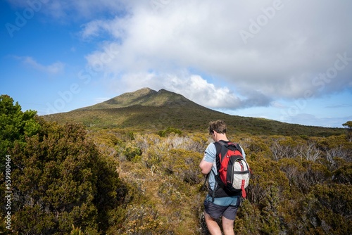 man hiking up a mountain with a backpack