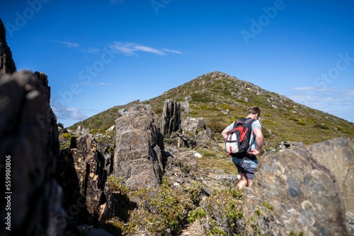 man hiking up a mountain with a backpack