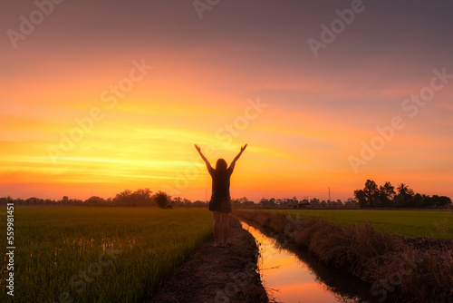 Scenic view landscape of woman relaxing in summer in mud and water reflection with Twilight blue bright and orange yellow dramatic sunset sky in beach cloudscape air background.People freedom style.