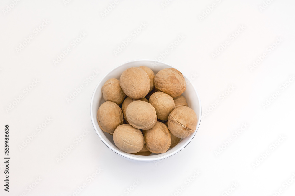 A cup with walnuts on a white background. Top view A cup with walnuts on a white background. Top view
