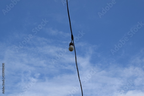 Electric light on blue sky in sunny weather. Lamp for home garden lighting.
