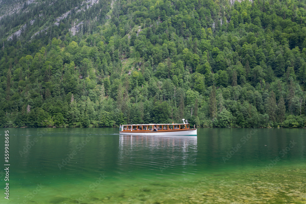 Passenger boat crossing the Königssee, a natural lake in the extreme southeast Berchtesgadener Land district of the German state of Bavaria, near the Austrian border Passenger boat crossing the Königssee, a natural lake in the extreme southeast Berchtesgadener Land district of the German state of Bavaria, near the Austrian border