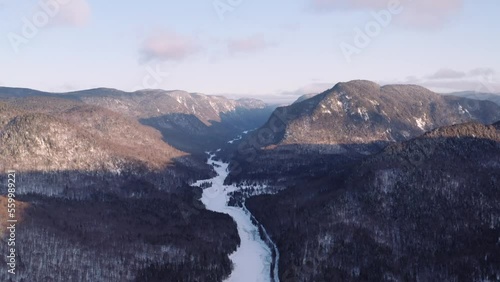 Dynamic aerial of sunrise over fjord in Quebec, Canada boreal forest Jacques Cartier National Park. photo