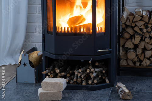 Foto Fuel briquettes made of pressed sawdust for kindling the furnace - economical alternative eco-friendly fuel for the fireplace in the house