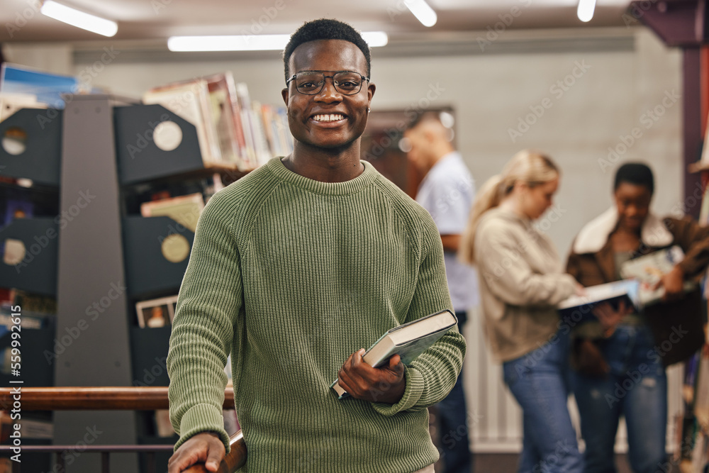 Black man, book and portrait in library with smile, research and studying at college for education. African gen z student, happy and university for books, learning or vision for future career goal - obrazy, fototapety, plakaty 