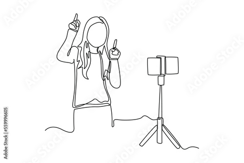 Continuous one line drawing Beautiful girl enjoys recording videos of herself dancing in front of a smartphone camera. Vlogging concept. Single line draw design vector graphic illustration.
