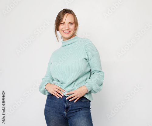 Pretty young blond woman wearing blue sweater with cute smile