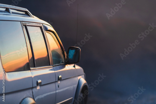 Traveling by 4x4 car  adventure in wildlife  expedition or extreme travel on a SUV. Part of vehicle at sunset  copy space.