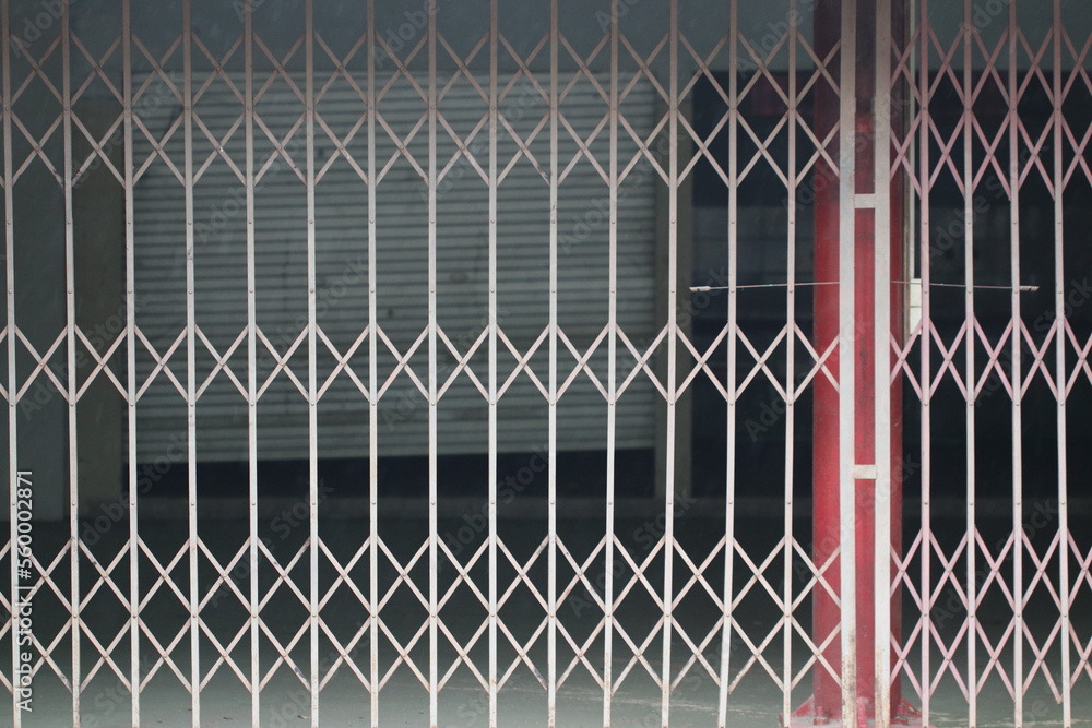 This image shows a store that has been closed with a steel fence. The