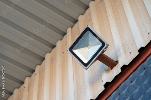 Solar powered led spotlight mounted on the outer wall of the warehouse