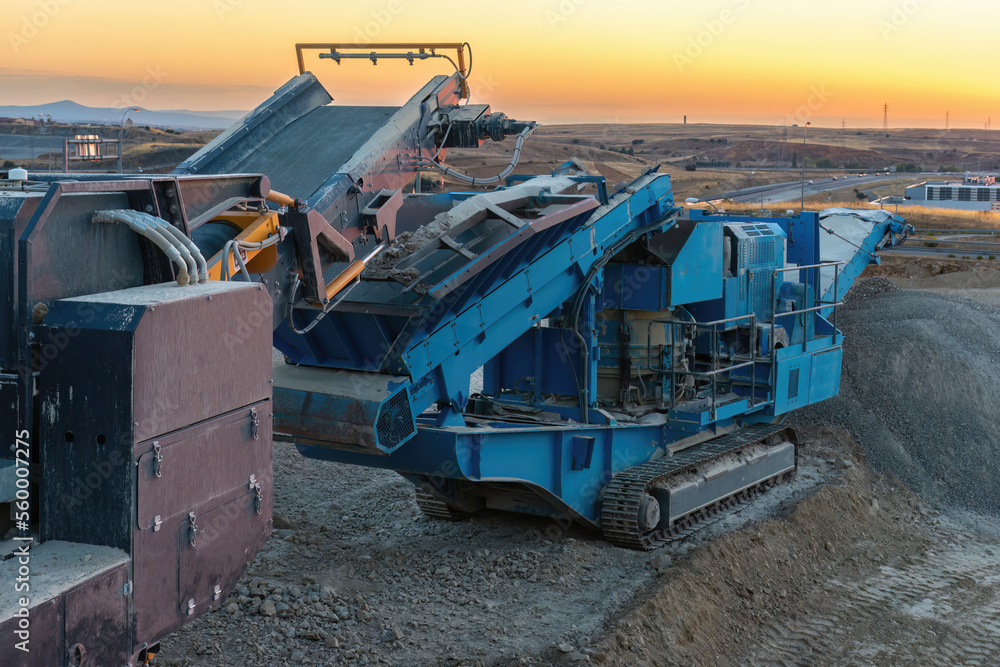 Heavy and mobile machinery in a quarry to transform stone into construction material Heavy and mobile machinery in a quarry to transform stone into construction material