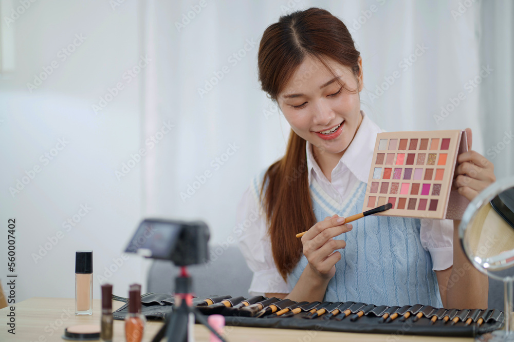 Beauty blogger. Cheerful asian vlogger is showing cosmetics products giving advices for her beauty blog Beauty blogger. Cheerful asian vlogger is showing cosmetics products giving advices for her beauty blog
