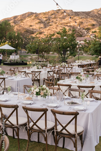 outdoor event, white chairs and tables placed outside