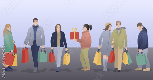 People with bags walk down the street after shopping