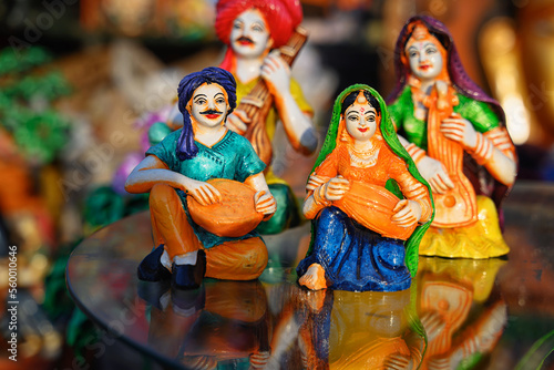Beautiful handmade dolls of miniature folk musicians performing in a band of classical Indian music is displayed in a shop for sale in blurred background. Indian art and handicraft.