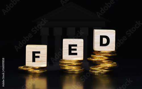 Text fed on wooden blocks on stack of gold coins, The Federal Reserve (FED) concept to control interest rates. World economy crisis gold coin background. Business concept.