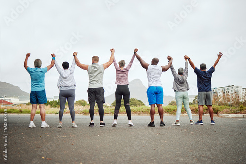 Holding hands, fitness group of people winning, yes or celebration exercise, workout and training goals in city rear. Wellness, community and senior friends teamwork, accountability and success sign