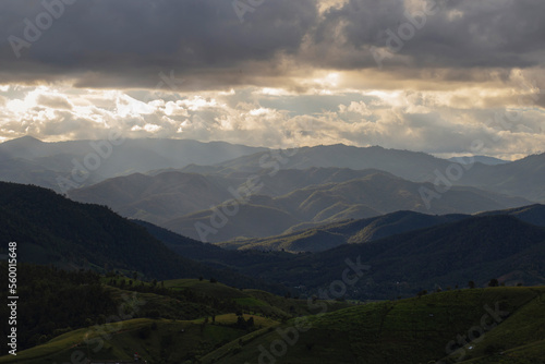 Views of mountains and forests with sunlight shining through the clouds.