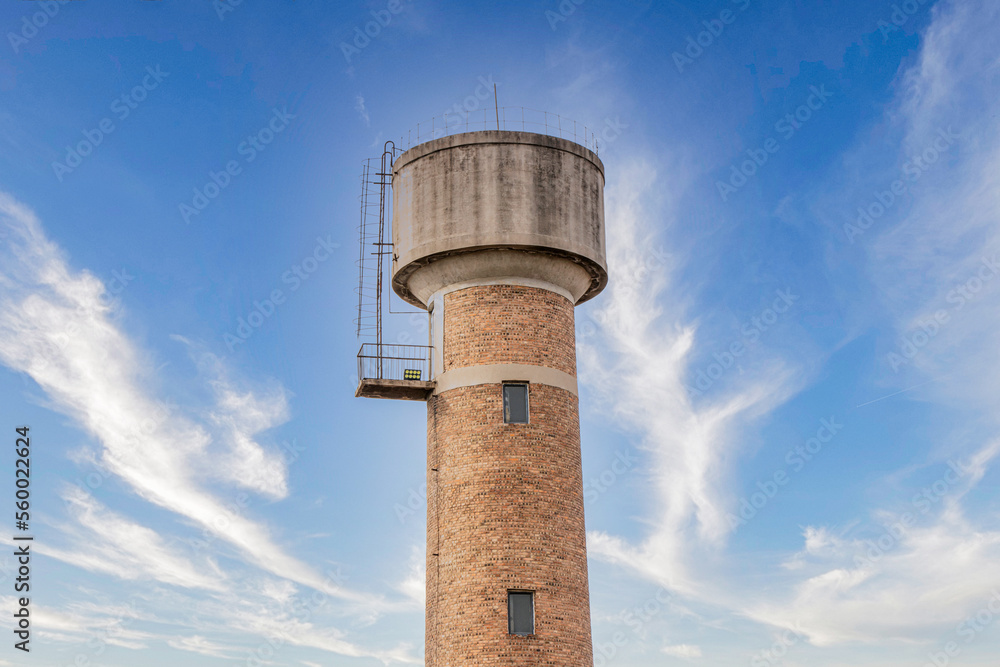 Old-fashioned water tower red brick water tower building blue sky and white clouds sunset sunset