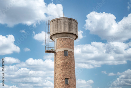 Old-fashioned water tower red brick water tower building blue sky and white clouds sunset sunset