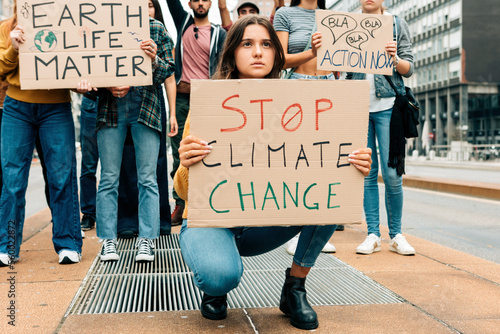 worried young woman holding up a stop climate change placard at a fridays for future street demonstration © Carlo