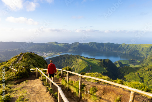 Hiker in a red jacket at the caldera on São Miguel island in the Azores photo