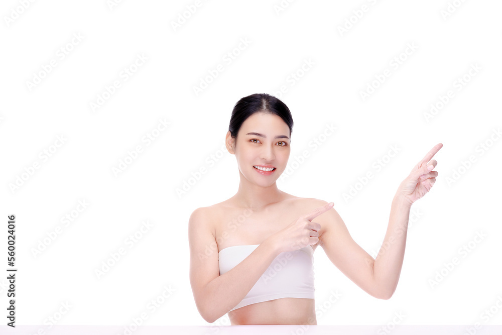 Beauty woman perfect face fresh clean skin pointing to empty copy space isolated on white. Beautiful spa Asian model girl with make up and beauty healthy skin color lips red and hair portrait.