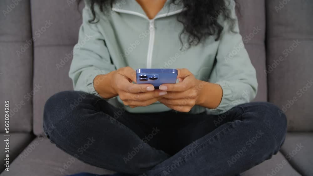 BIPOC woman typing sms message on mobile phone. Young POC female using modern blue smartphone for communication BIPOC woman typing sms message on mobile phone. Young POC female using modern blue smartphone for communication