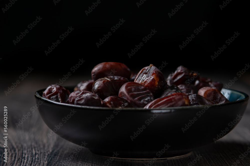 dates and nuts in a bowl on a dark background dates and nuts in a bowl on a dark background