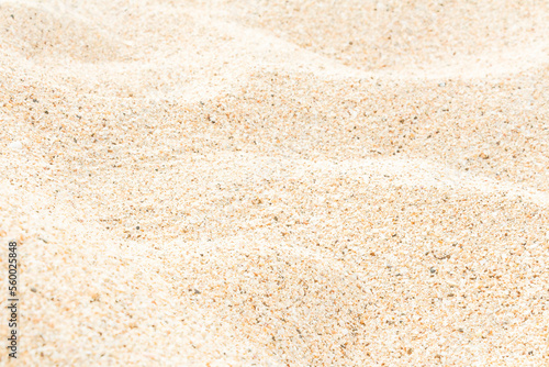 Sandy beach in summer sun light texture natural background, soft focus.