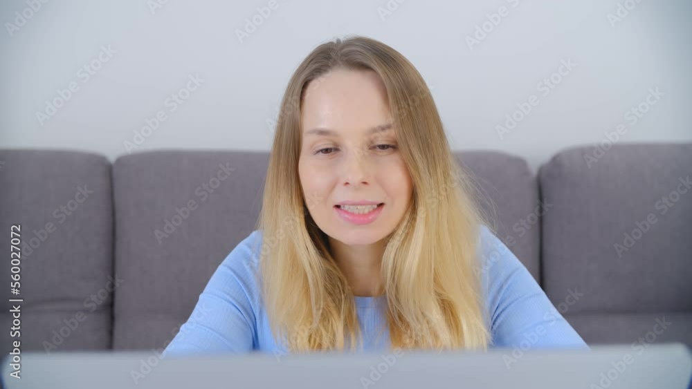 Freelancer women in early 40s works on computer at home. Cheerful Ukrainian female person typing text on notebook with a smile Freelancer women in early 40s works on computer at home. Cheerful Ukrainian female person typing text on notebook with a smile