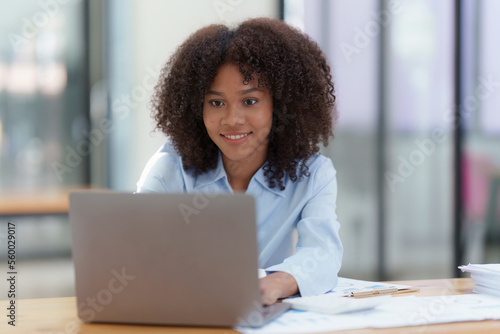 Young African American businesswoman working by laptop at office, Focus at screen laptop, reading interesting article online and finance