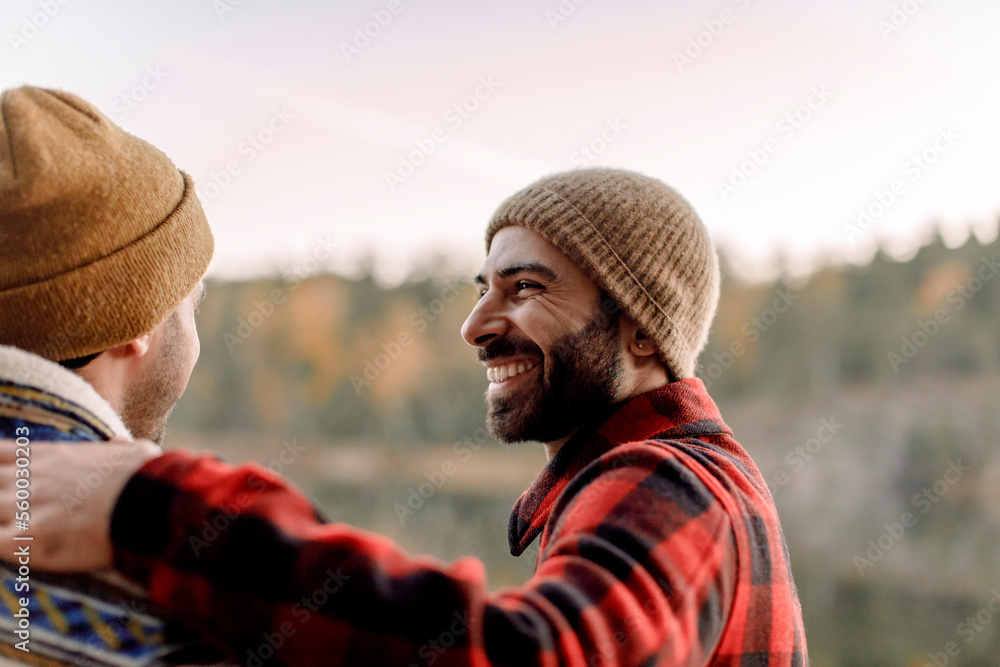 © Maskot - Side view of happy man with beard looking at male friend © Maskot - Side view of happy man with beard looking at male friend
