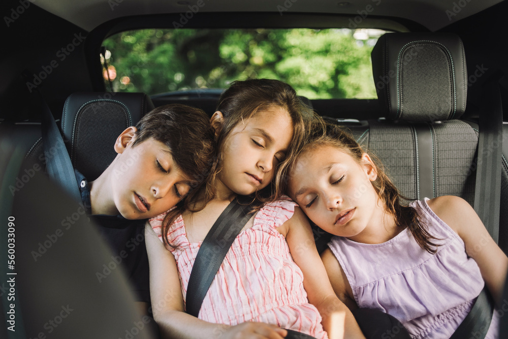 Tired siblings sleeping on back seat while traveling in car Tired siblings sleeping on back seat while traveling in car