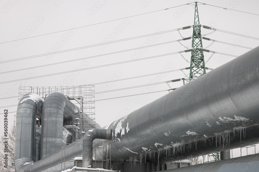 pipeline and power line in the city in winter against the gray sky. pipeline and power line in the city in winter against the gray sky.