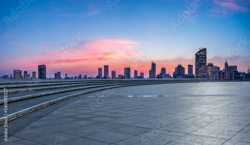 Empty square floor and city skyline with modern buildings at sunset in Shanghai, China.