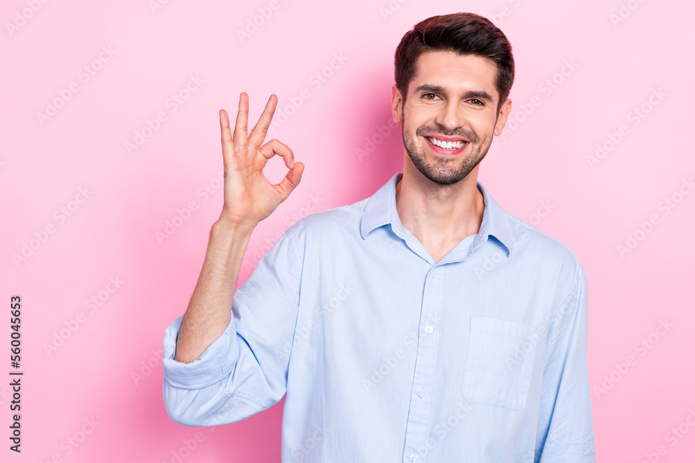 Photo of positive glad man wear stylish clothes arm demonstrate okey symbol done finish task empty space isolated on pink color background Photo of positive glad man wear stylish clothes arm demonstrate okey symbol done finish task empty space isolated on pink color background