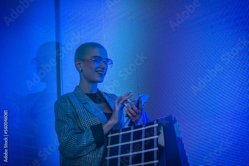 Image of a beautiful young woman posing against a led panel. photo