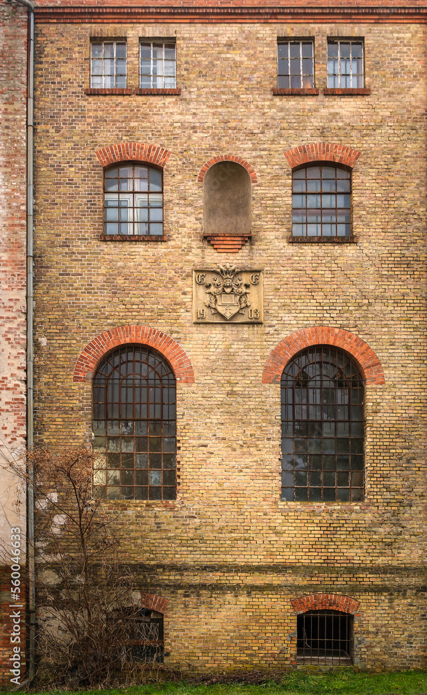 Fassade des Hauptgebäudes der denkmalgeschützten Papierfabrik in Spechthausen mit dem Firmenwappen und der Jahreszahl 1903