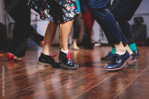 Dancing shoes of young couple dance retro jazz swing dances on a ballroom club wooden floor, close up view of shoes, female and male, dance lessons class rehearsal