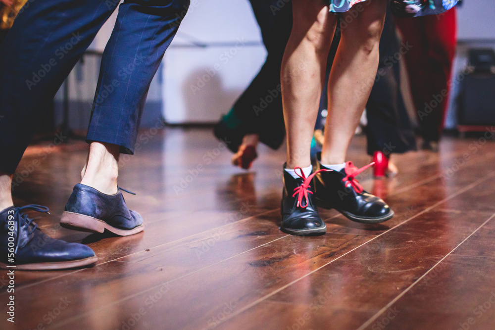 Dancing shoes of young couple dance retro jazz swing dances on a ballroom club wooden floor, close up view of shoes, female and male, dance lessons class rehearsal Dancing shoes of young couple dance retro jazz swing dances on a ballroom club wooden floor, close up view of shoes, female and male, dance lessons class rehearsal