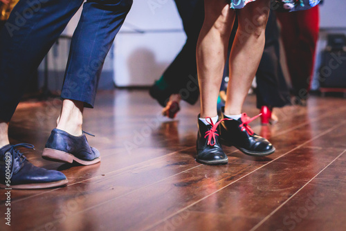 Dancing shoes of young couple dance retro jazz swing dances on a ballroom club wooden floor, close up view of shoes, female and male, dance lessons class rehearsal © tsuguliev