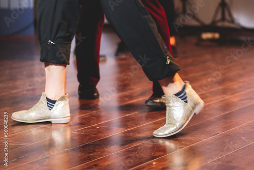 Dancing shoes of young couple dance retro jazz swing dances on a ballroom club wooden floor  close up view of shoes  female and male  dance lessons class rehearsal