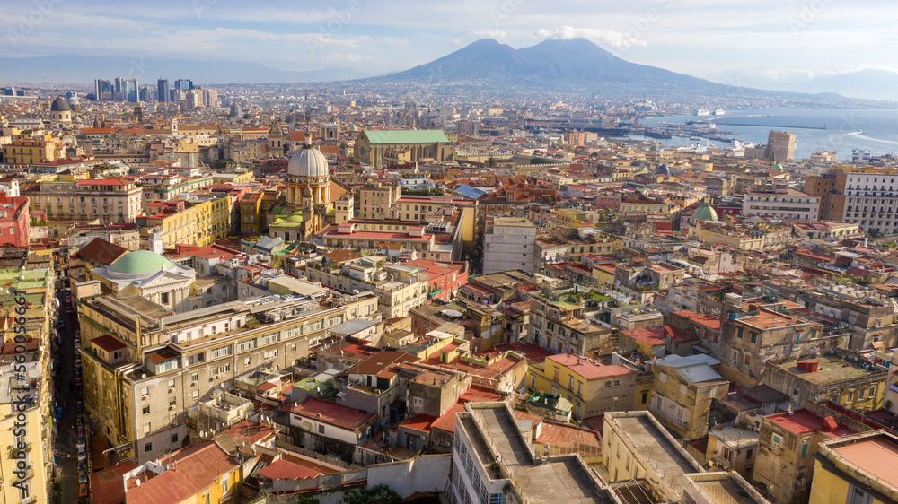 Aerial view of the city of Naples, Italy, and the harbour on a sunny day. The volcano Vesuvius in the background.
