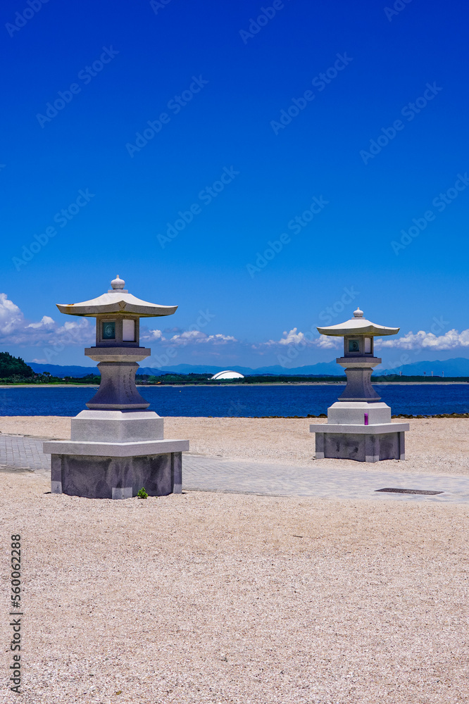 Fototapeta premium 広い海岸に立つ青島神社の石灯籠（宮崎県宮崎市）