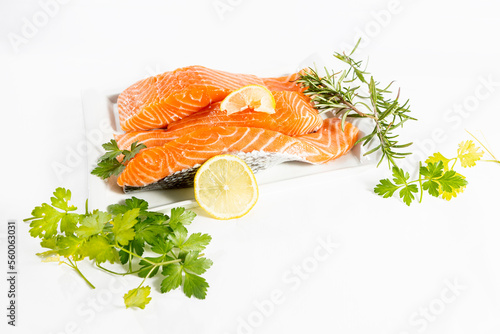Картината върху платно Plate of raw and fresh salmon fillets with herbs, parsley and lemon on a white b