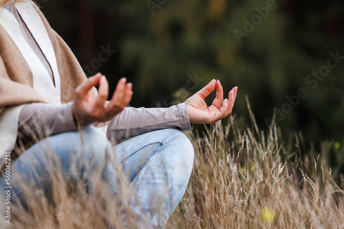 Woman practicing yoga exercise in lotus position. Meditation outdoors