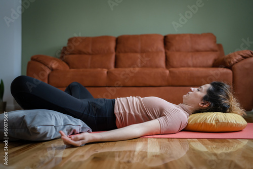 One adult caucasian woman practice restorative yoga at home